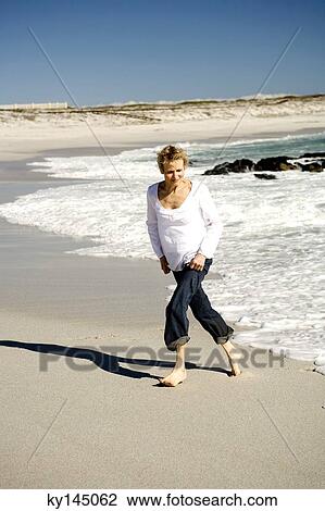 Senior woman walking on beach View Large Photo Image Stock Image - Senior woman walking on beach. Fotosearch
