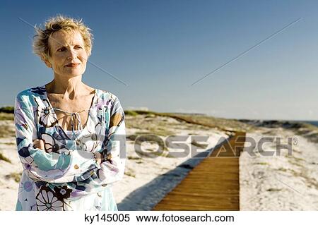 Senior woman with arms crossed at seaside View Large Photo Image Stock Photography - Senior woman with arms crossed at seaside. Fotosearch