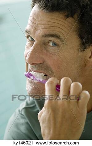 Man brushing his teeth, indoors View Large Photo Image Stock Image - Man brushing his teeth, indoors. Fotosearch