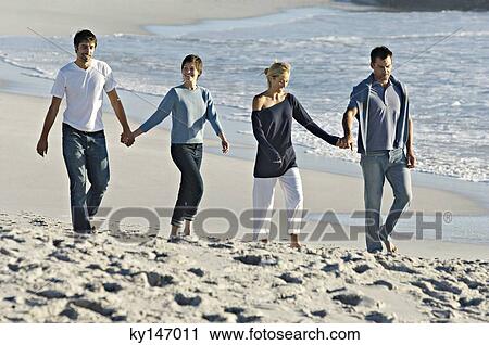 2 couples holding hands, walking on the beach View Large Photo Image Stock Image - 2 couples holding hands, walking on the beach. Fotosearch