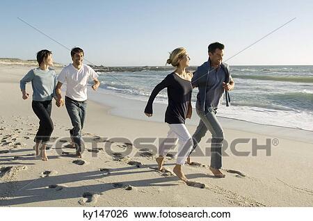 2 couples running on the beach View Large Photo Image Stock Photograph - 2 couples running on the beach. Fotosearch