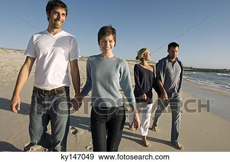 2 couples walking on the beach View Large Photo Image Stock Photo - 2 couples walking on the beach. Fotosearch