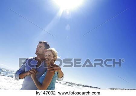 Couple embracing on the beach View Large Photo Image Stock Image - Couple embracing on the beach. Fotosearch