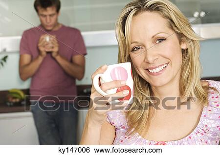 Couple holding mugs in kitchen View Large Photo Image Stock Photograph - Couple holding mugs in kitchen. Fotosearch