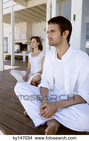 Couple sitting cross-legged on wooden terrace View Large Photo Image Picture - Couple sitting cross-legged on wooden terrace. Fotosearch