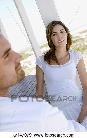 Couple sitting on wooden terrace View Large Photo Image Stock Photo - Couple sitting on wooden terrace. Fotosearch