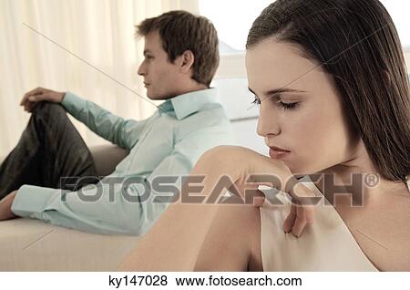 Stock Photo - Couple sulking in living-room. Fotosearch