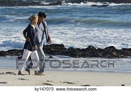 Couple walking on the beach View Large Photo Image Stock Image - Couple walking on the beach. Fotosearch