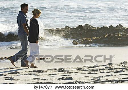 Couple walking on the beach View Large Photo Image Stock Photo - Couple walking on the beach. Fotosearch