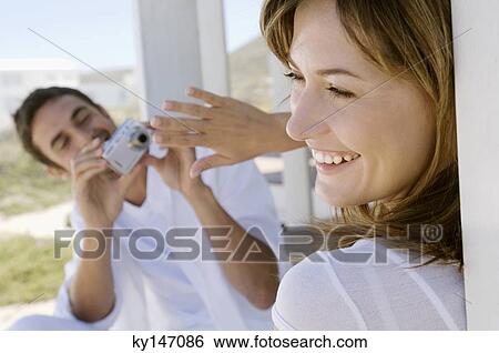 Man photographing young smiling woman View Large Photo Image Stock Photograph - Man photographing young smiling woman. Fotosearch