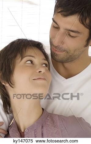 Stock Photography - Portrait of embracing couple looking at each other. Fotosearch