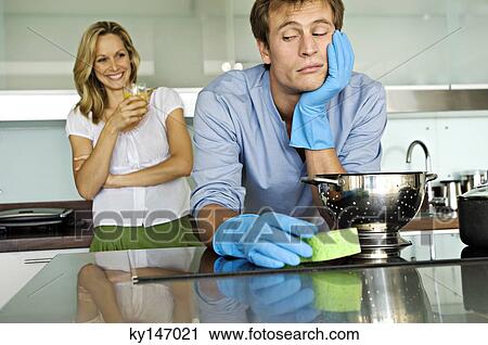 Smiling woman looking at sulking man holding sponge View Large Photo Image Stock Image - Smiling woman looking at sulking man holding sponge. Fotosearch