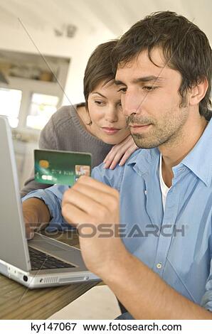 Young couple using credit card on internet View Large Photo Image Stock Photo - Young couple using credit card on internet. Fotosearch
