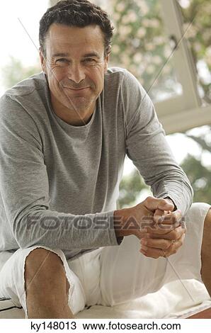 Man sitting, smiling for camera View Large Photo Image Stock Image - Man sitting, smiling for camera. Fotosearch