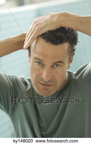 Portrait of a man doing his hair View Large Photo Image Stock Image - Portrait of a man doing his hair. Fotosearch