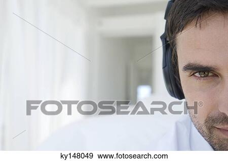 Portrait of a young man listening to music with headphones View Large Photo Image Stock Photo - Portrait of a young man listening to music with headphones. Fotosearch
