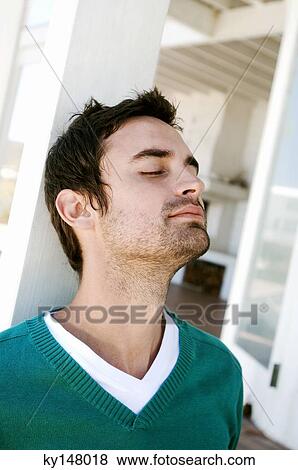 Portrait of a young man with eyes closed, leaning against terrace beam View Large Photo Image Stock Photo - Portrait of a young man with eyes closed, leaning against terrace beam. Fotosearch