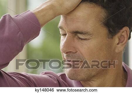 Stock Photograph - Portrait of man with hand on forehand, eyes closed. Fotosearch