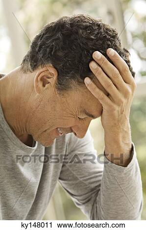 Stock Image - Portrait of man with hand on forehead. Fotosearch