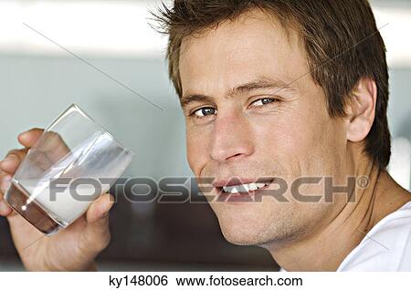 Portrait of young man drinking milk View Large Photo Image Stock Photograph - Portrait of young man drinking milk. Fotosearch