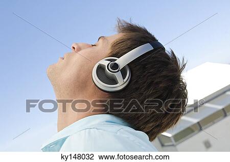 Portrait of young man listening to music with headphones View Large Photo Image Stock Image - Portrait of young man listening to music with headphones. Fotosearch
