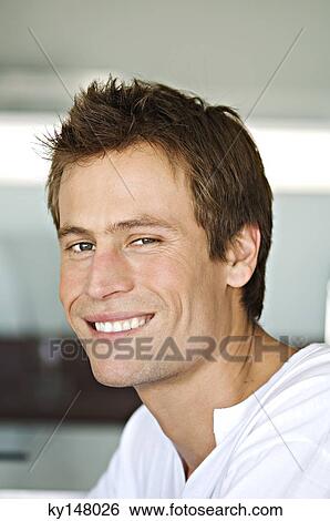 Portrait of young man smiling for the camera View Large Photo Image Stock Photograph - Portrait of young man smiling for the camera. Fotosearch