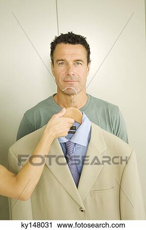Woman giving suit to man View Large Photo Image Stock Image - Woman giving suit to man. Fotosearch