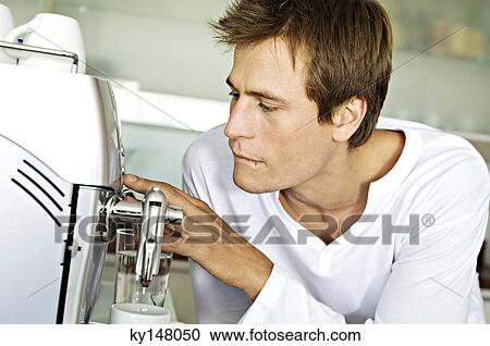 Young man using espresso maker View Large Photo Image Stock Image - Young man using espresso maker. Fotosearch