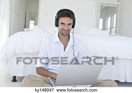 Stock Photo - Young man using laptop. Fotosearch