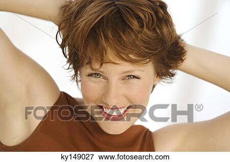 Portrait of young smiling woman, hands behind head View Large Photo Image Stock Photo - Portrait of young smiling woman, hands behind head. Fotosearch