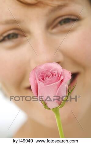 Portrait of young smiling woman with rose in front of face View Large Photo Image Stock Photo - Portrait of young smiling woman with rose in front of face. Fotosearch