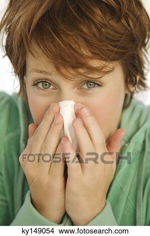 Portrait of young woman blowing her nose View Large Photo Image Picture - Portrait of young woman blowing her nose. Fotosearch