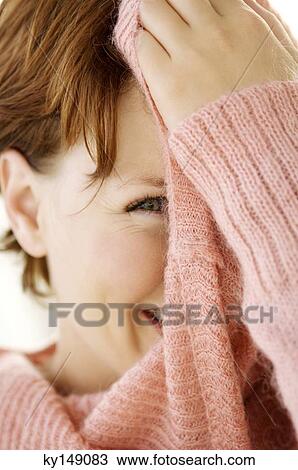 Portrait of young woman covering her face with jumper View Large Photo Image Stock Image - Portrait of young woman covering her face with jumper. Fotosearch