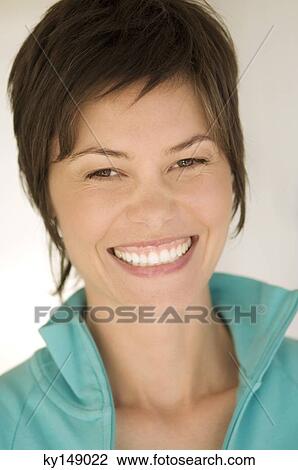 Portrait of young woman smiling for the camera View Large Photo Image Stock Image - Portrait of young woman smiling for the camera. Fotosearch