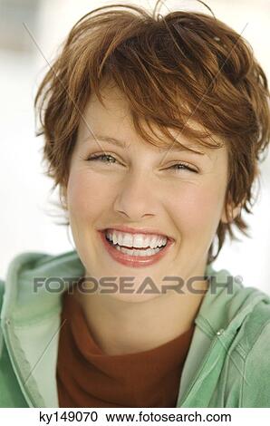 Portrait of young woman smiling for the camera View Large Photo Image Stock Image - Portrait of young woman smiling for the camera. Fotosearch