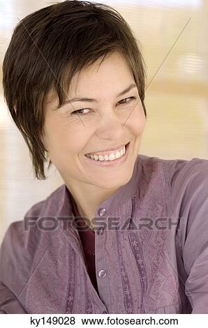 Portrait of young woman smiling for the camera View Large Photo Image Stock Photo - Portrait of young woman smiling for the camera. Fotosearch