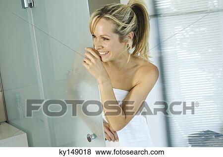 Young smiling woman wrapped in towel in bathroom View Large Photo Image Stock Photo - Young smiling woman wrapped in towel in bathroom. Fotosearch