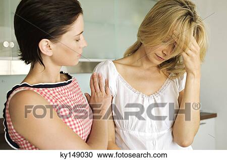 Stock Image - Young woman consoling another. Fotosearch