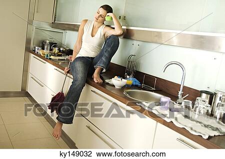 Young woman looking tired, in kitchen View Large Photo Image Stock Image - Young woman looking tired, in kitchen. Fotosearch