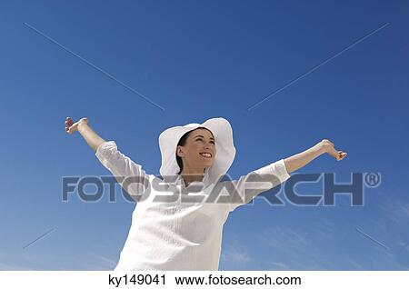 Young woman with arms up, outdoors View Large Photo Image Stock Image - Young woman with arms up, outdoors. Fotosearch