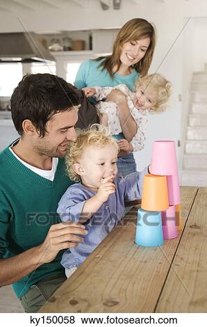 Couple and 2 children playing in kitchen View Large Photo Image Stock Photo - Couple and 2 children playing in kitchen. Fotosearch