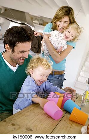 Couple and 2 children playing in kitchen View Large Photo Image Stock Photograph - Couple and 2 children playing in kitchen. Fotosearch