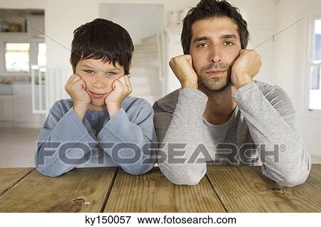 Father and son looking at camera, with hands on cheeks View Large Photo Image Stock Photo - Father and son looking at camera, with hands on cheeks. Fotosearch