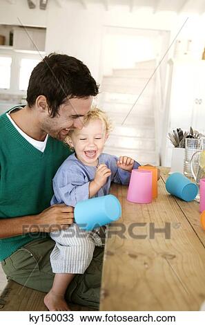 Father and son playing in kitchen View Large Photo Image Stock Image - Father and son playing in kitchen. Fotosearch