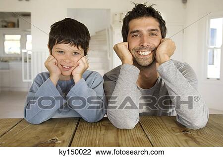 Father and son smiling for the camera, with hands on cheeks View Large Photo Image Stock Image - Father and son smiling for the camera, with hands on cheeks. Fotosearch