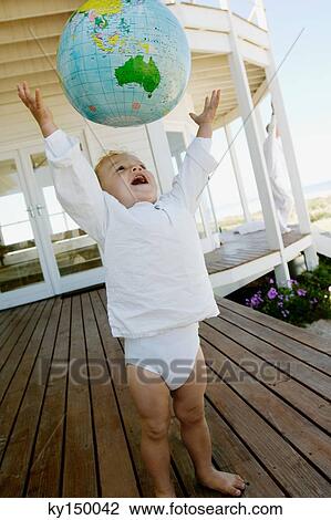 Little boy throwing inflatable globe in the air View Large Photo Image Stock Image - Little boy throwing inflatable globe in the air. Fotosearch