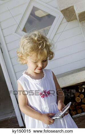 Little girl holding mobile phone View Large Photo Image Stock Photography - Little girl holding mobile phone. Fotosearch