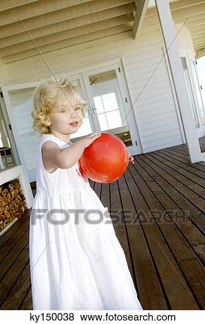 Little girl holding red ball on wooden terrace View Large Photo Image Stock Photo - Little girl holding red ball on wooden terrace. Fotosearch