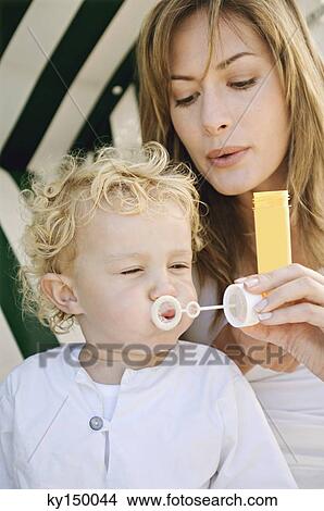 Mother and son blowing soap bubbles View Large Photo Image Picture - Mother and son blowing soap bubbles. Fotosearch
