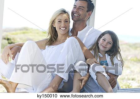 Parents and daughter smiling for the camera, outdoors View Large Photo Image Stock Image - Parents and daughter smiling for the camera, outdoors. Fotosearch